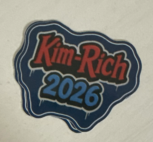 The Kim-Rich 2026 sticker: red and pale blue bubble letters on a navy die-cut blob